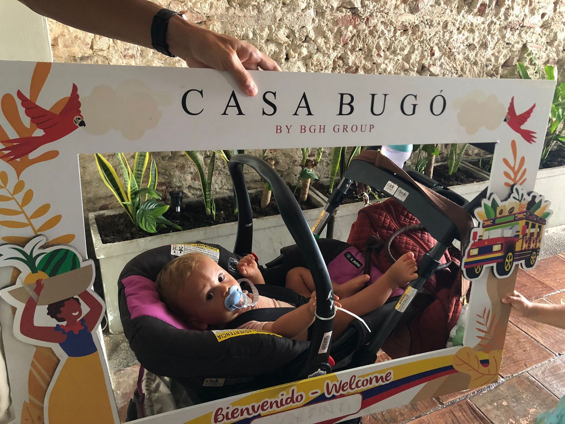 A baby in a stroller is behind a sign that says casa burgo