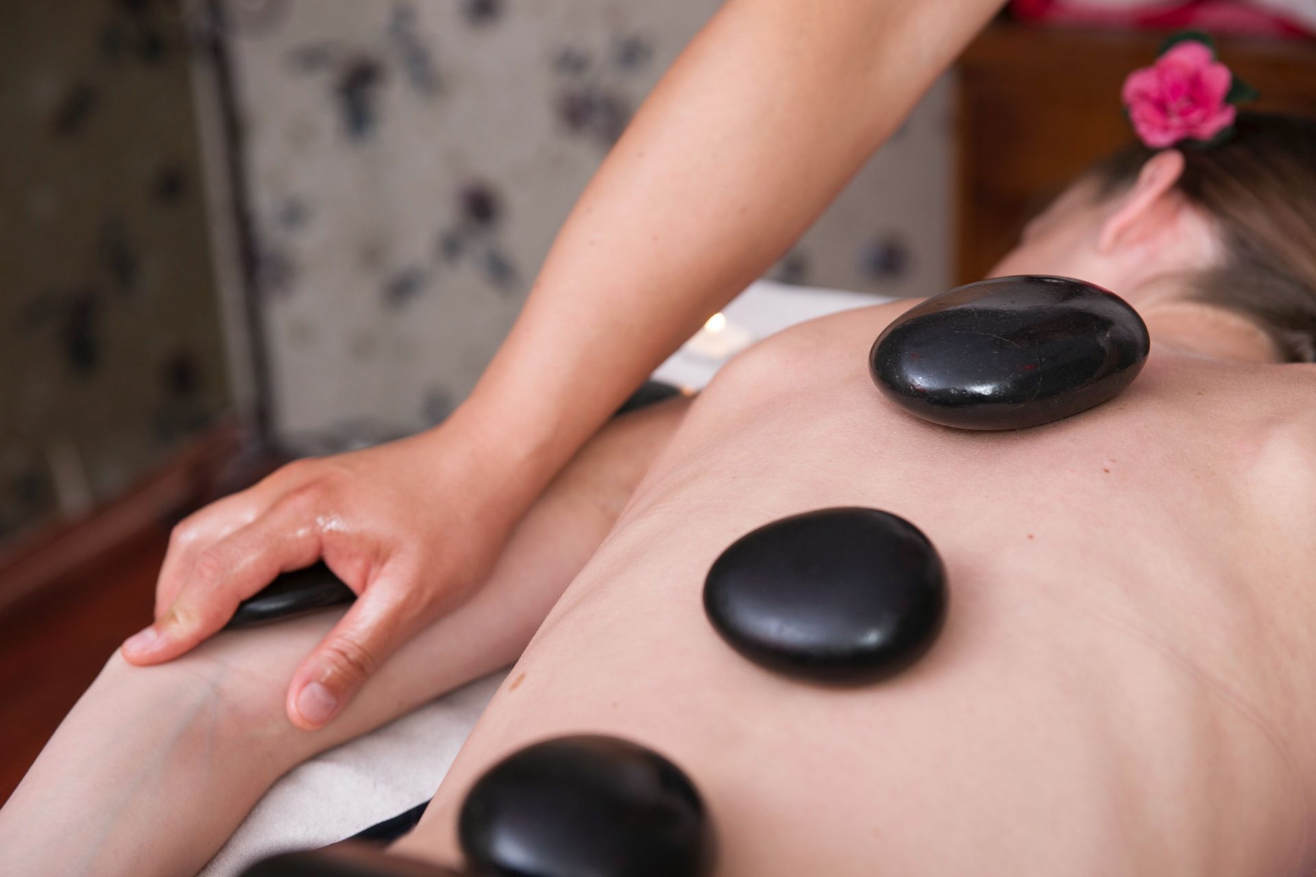 A woman is getting a hot stone massage at a spa.