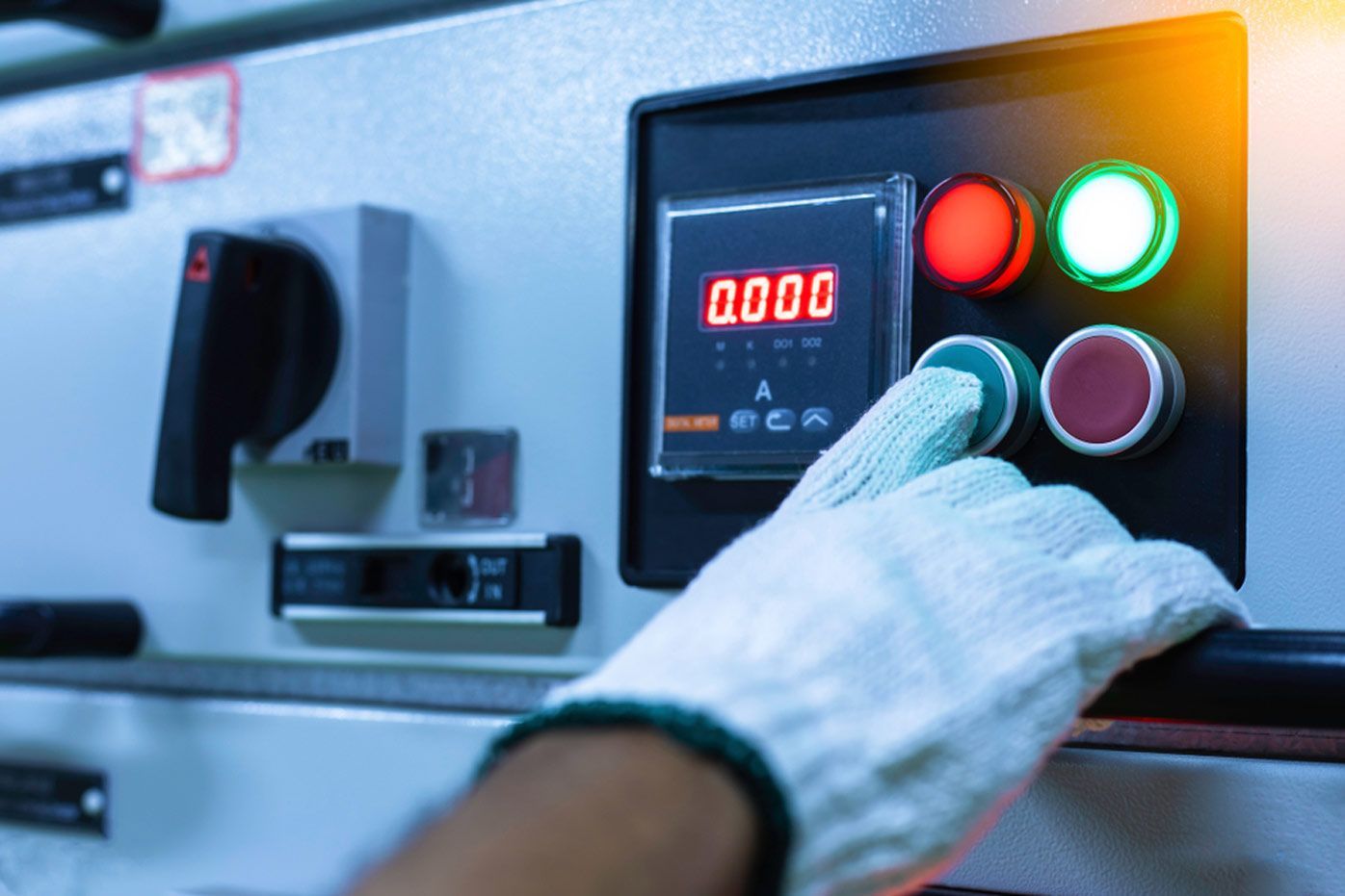 A Person Wearing Gloves is Pressing a Button on a Machine — Cairns Synergy Electrical in Manunda, QLD