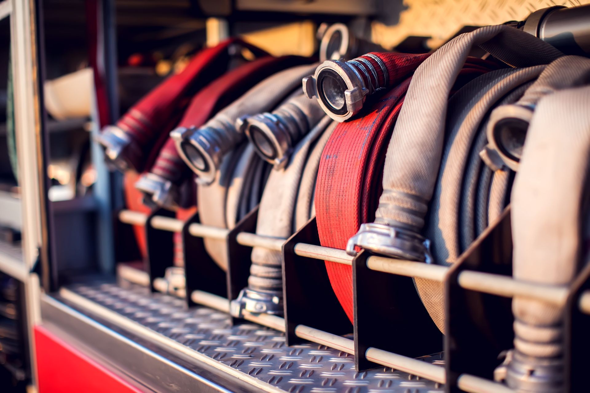Fire hoses coiled and stored inside a fire truck, ready for use.