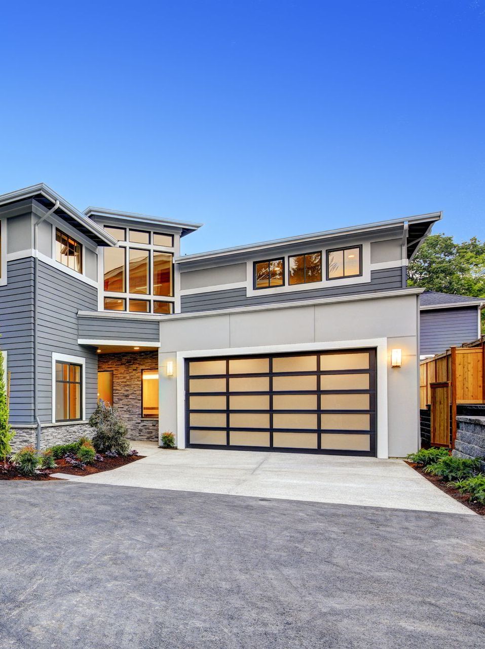 A large house with a large garage door and a lot of windows.