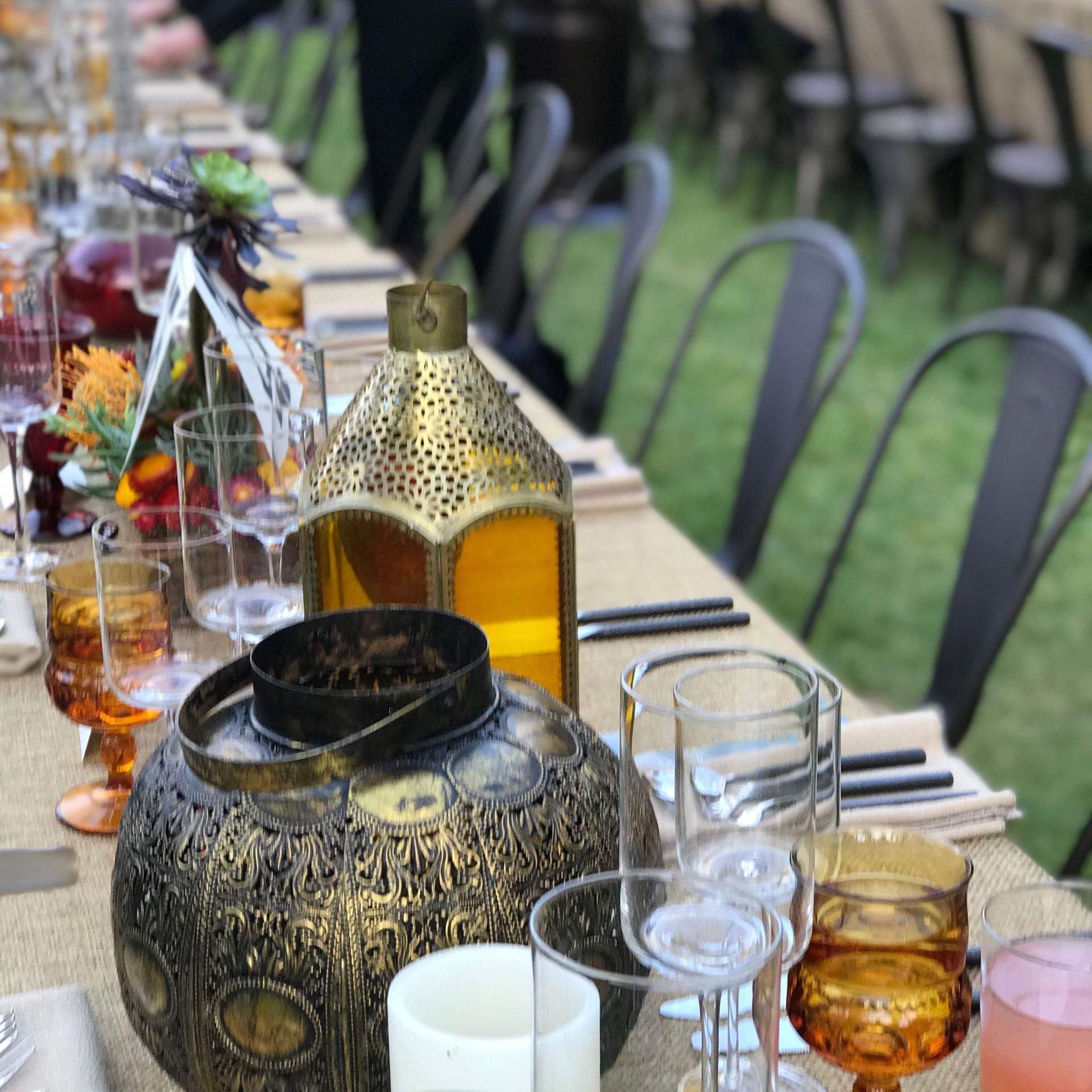 A long table with wine glasses and candles on it