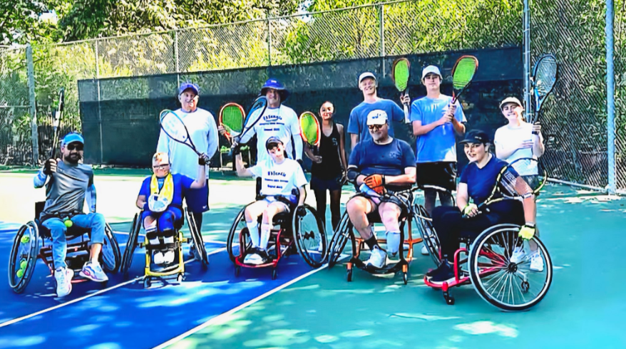 A group of people standing in front of a scoreboard that says welcome kot3 thns