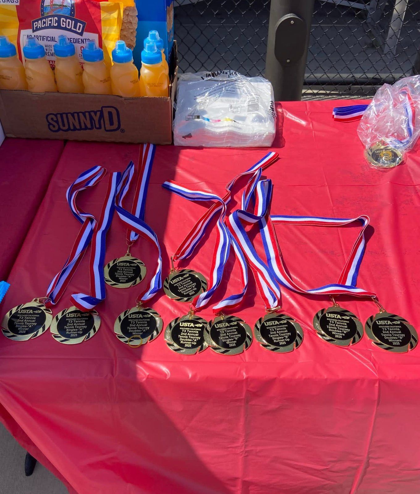 A table with medals and bottles of sunny d on it