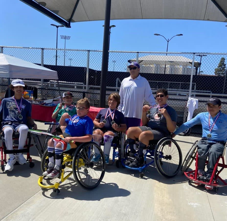 A group of people in wheelchairs are posing for a picture