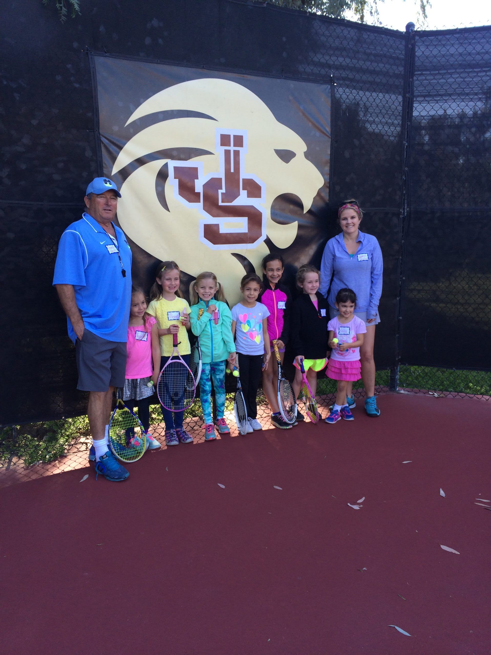 A group of children are posing for a picture in front of a cs logo