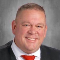 A man in a suit and tie is smiling for the camera.