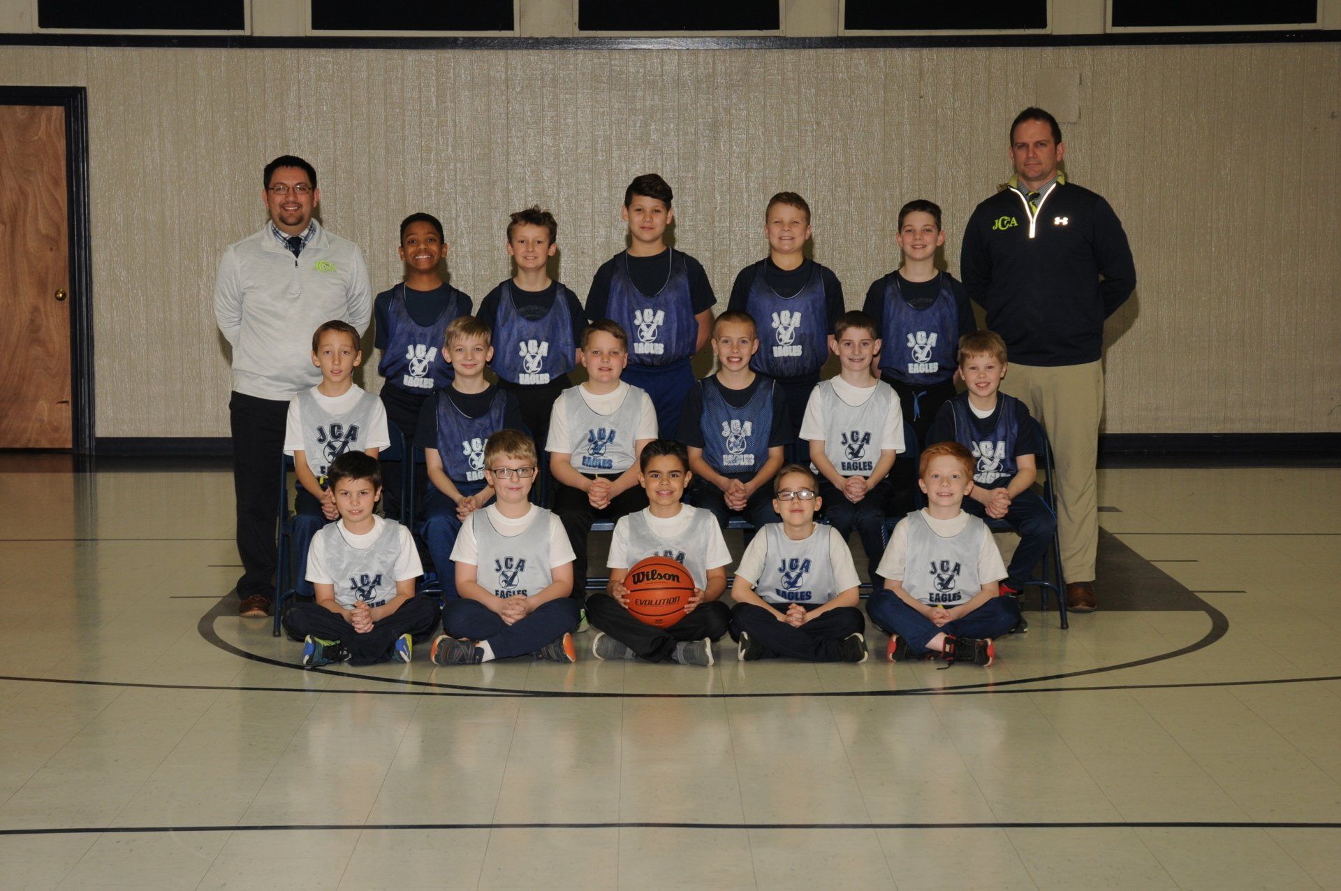 A basketball team poses for a picture in a gym