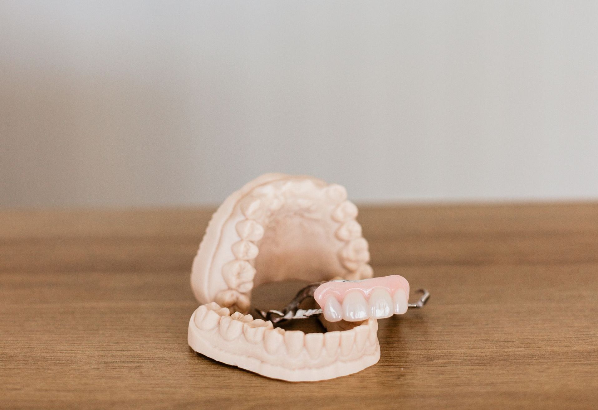 A Person Is Working On A Model Of A Person's Teeth — Harvey Smiles Denture Clinic In Burleigh Heads, QLD