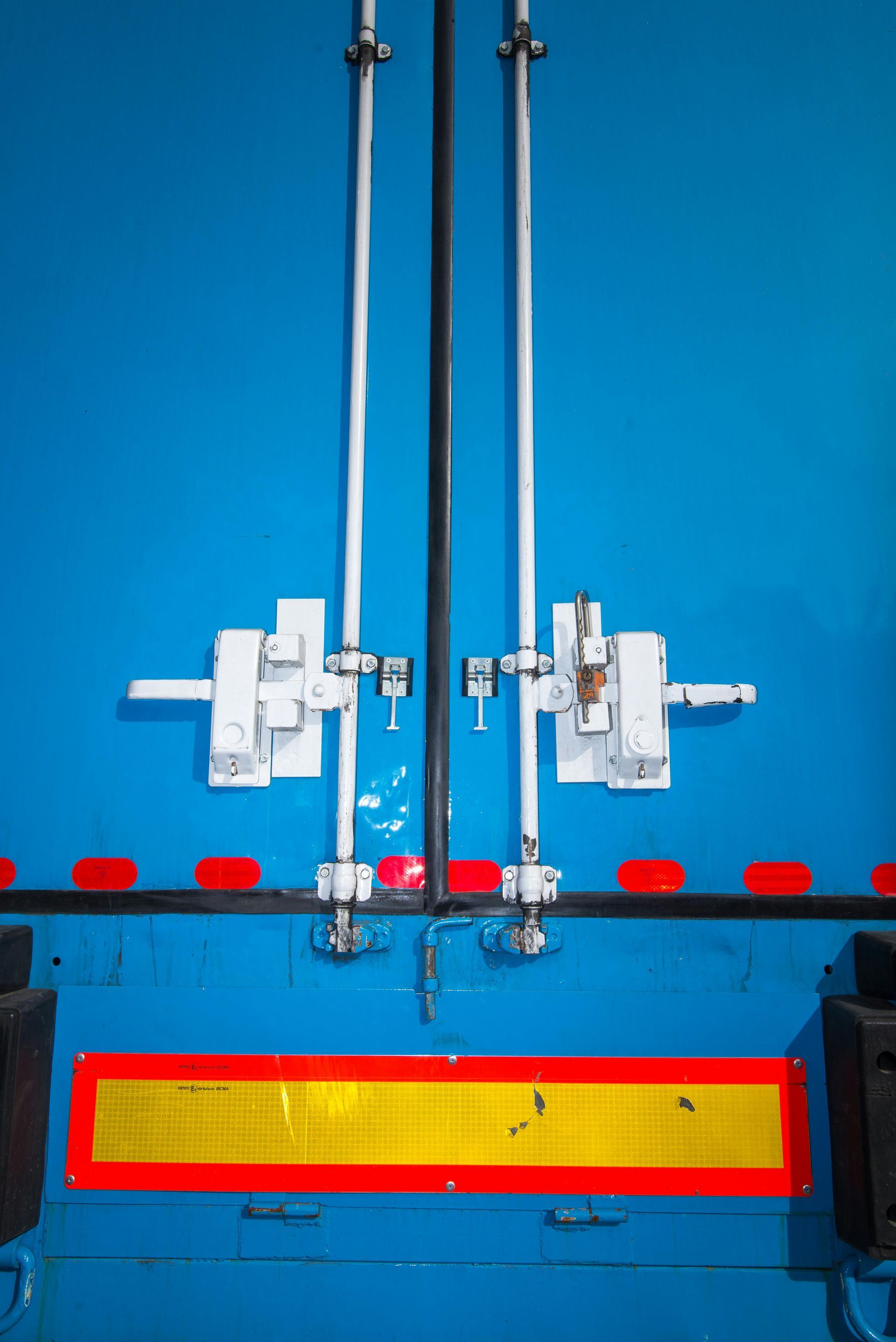 A close up of the back of a blue truck with locks on it.