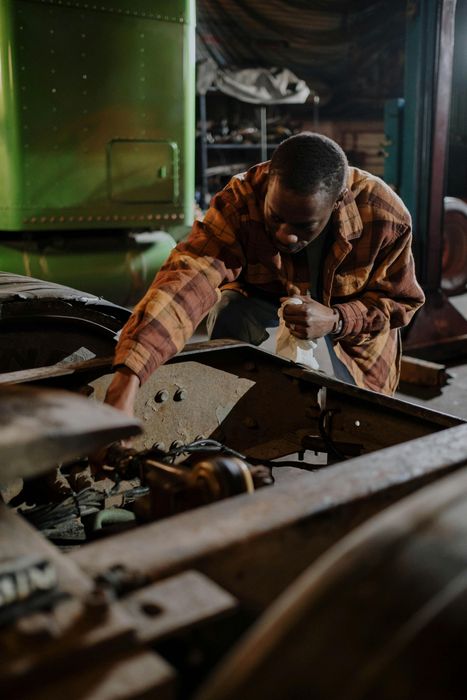 A man is working on a car engine in a garage.