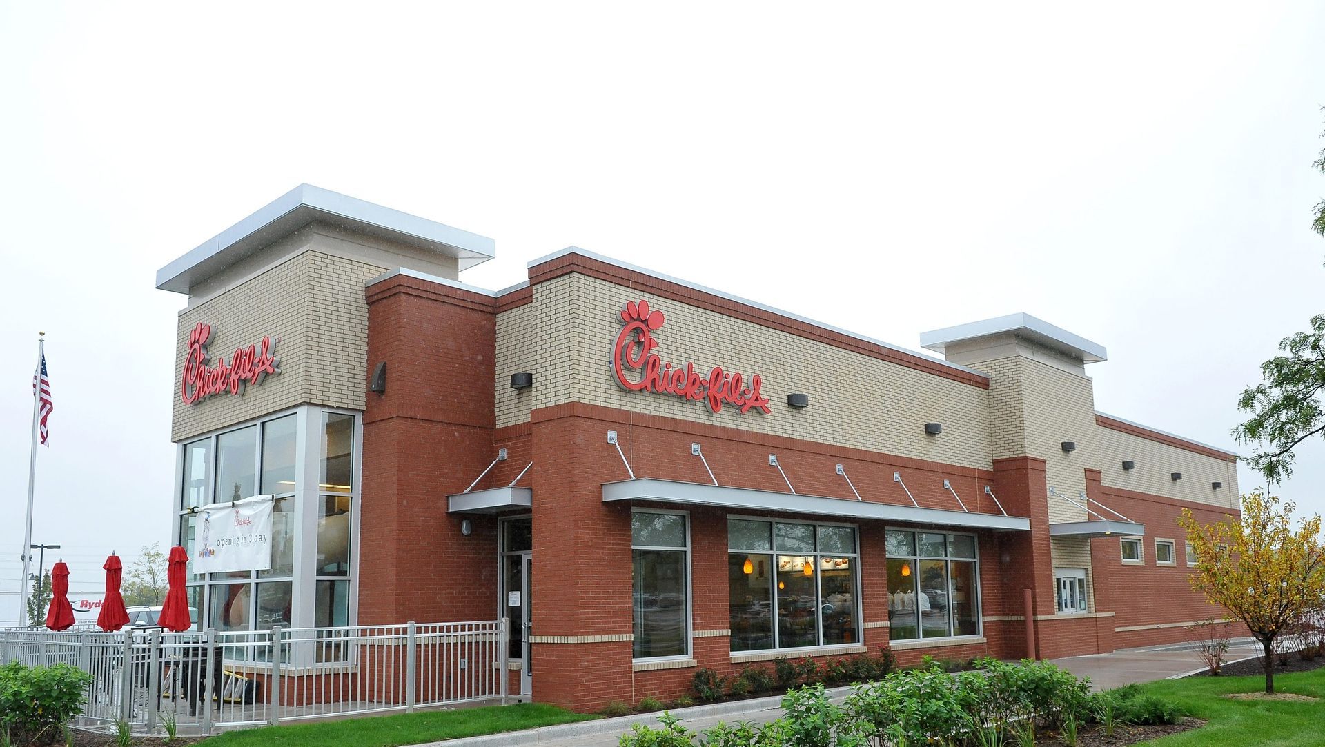 Chick-fil-A restaurant with red brick exterior, tan accents, and large windows. The logo is visible.