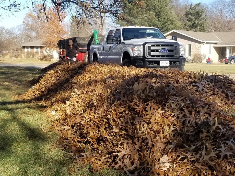 A truck is parked next to a pile of leaves.