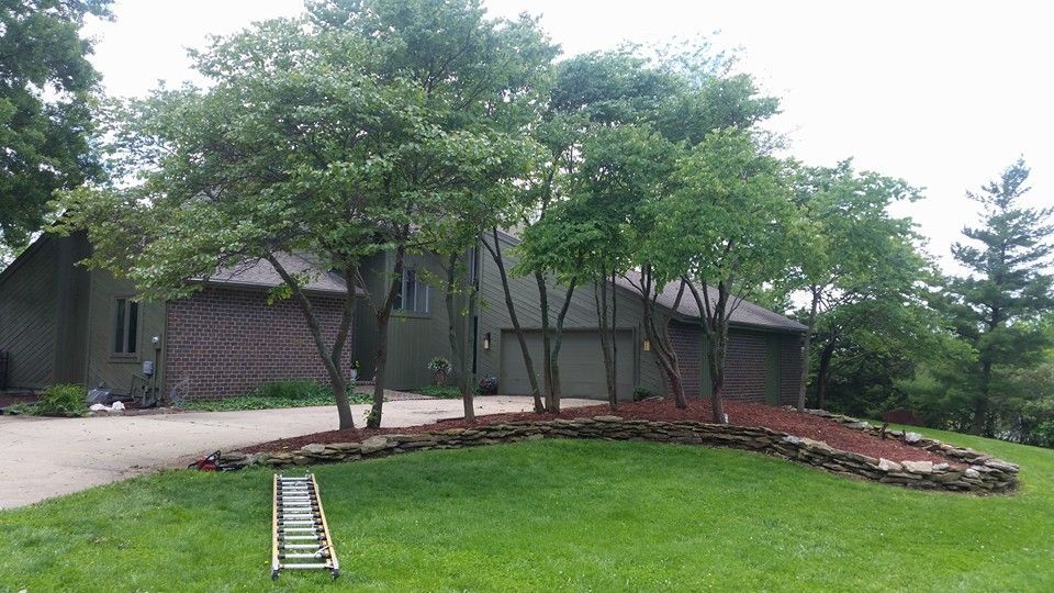 A ladder is sitting in the grass in front of a house.