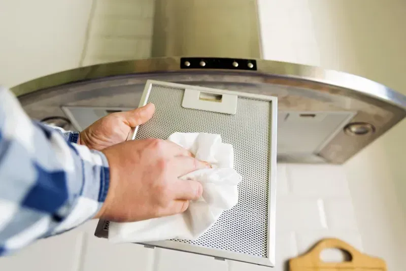 A Person in a Plaid Shirt Uses a White Cloth — Eurocoast Appliance Service In Tuggerah, NSW