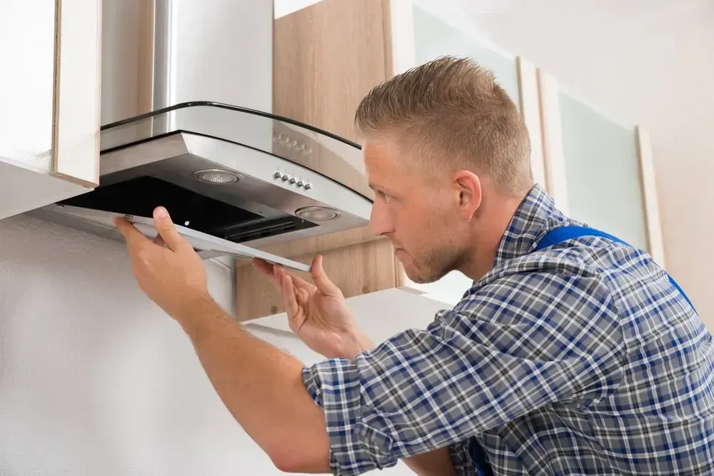 Technician Installs a Stainless Steel Kitchen — Eurocoast Appliance Service In Tuggerah, NSW