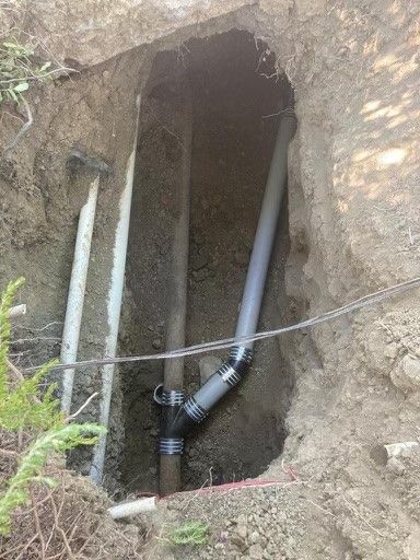 A pipe is being installed in a hole in the ground.