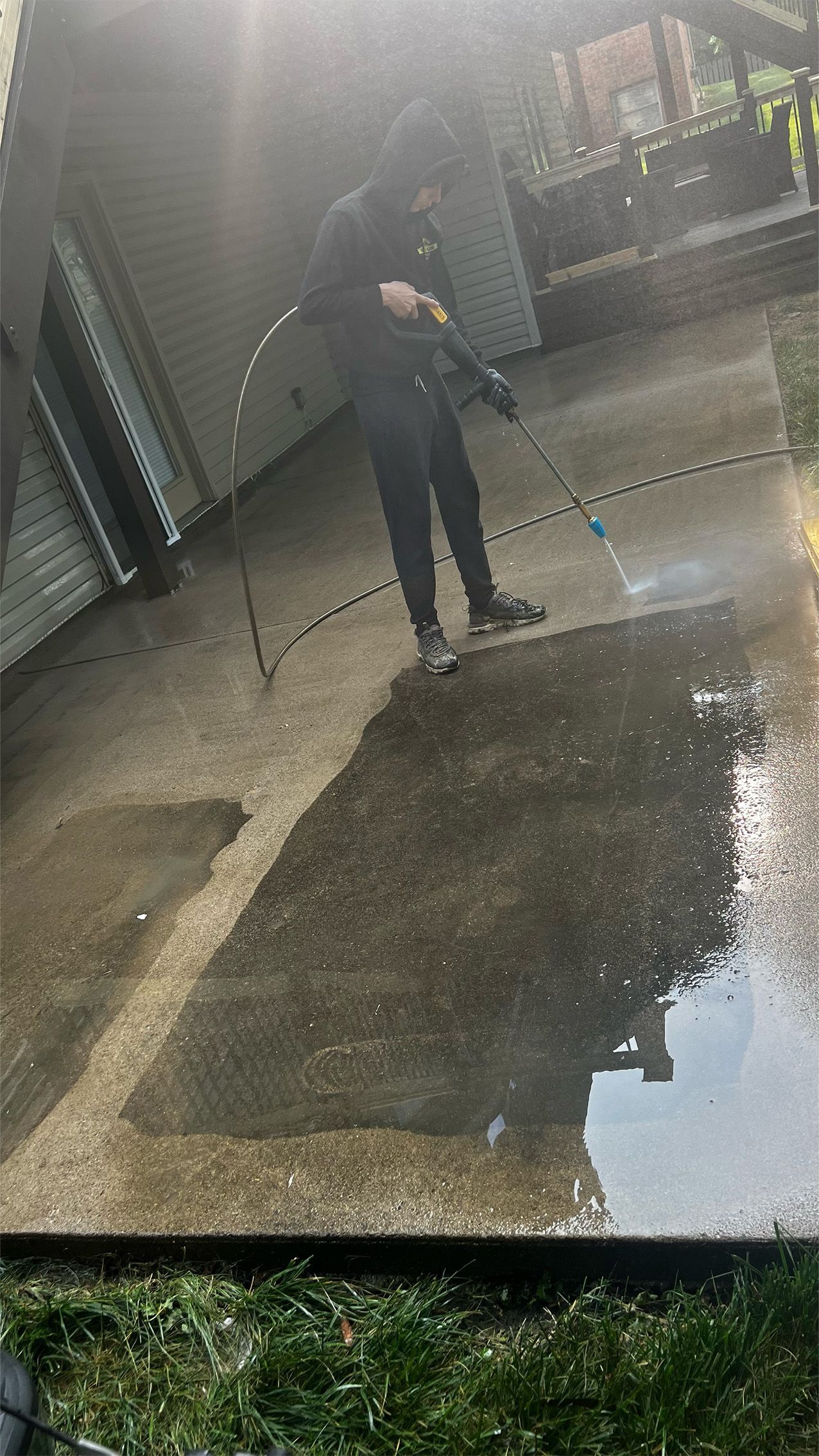 A person is cleaning a driveway with a high pressure washer.