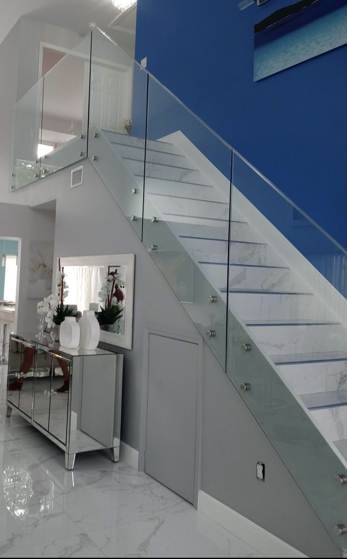 A staircase with a glass railing in a living room