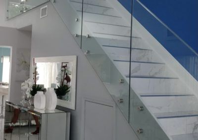 A staircase with a glass railing in a living room