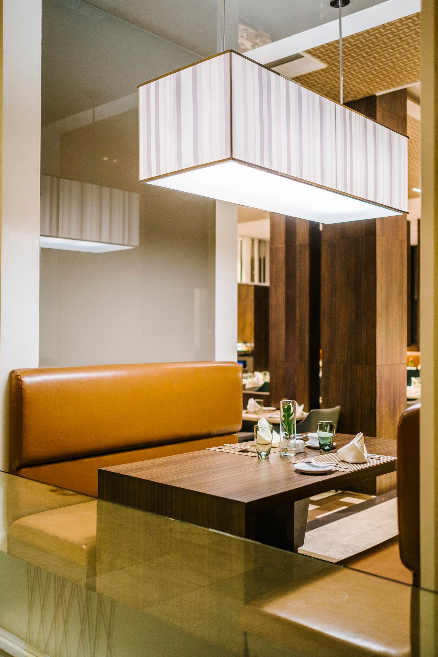 A restaurant booth with a table and a light hanging from the ceiling