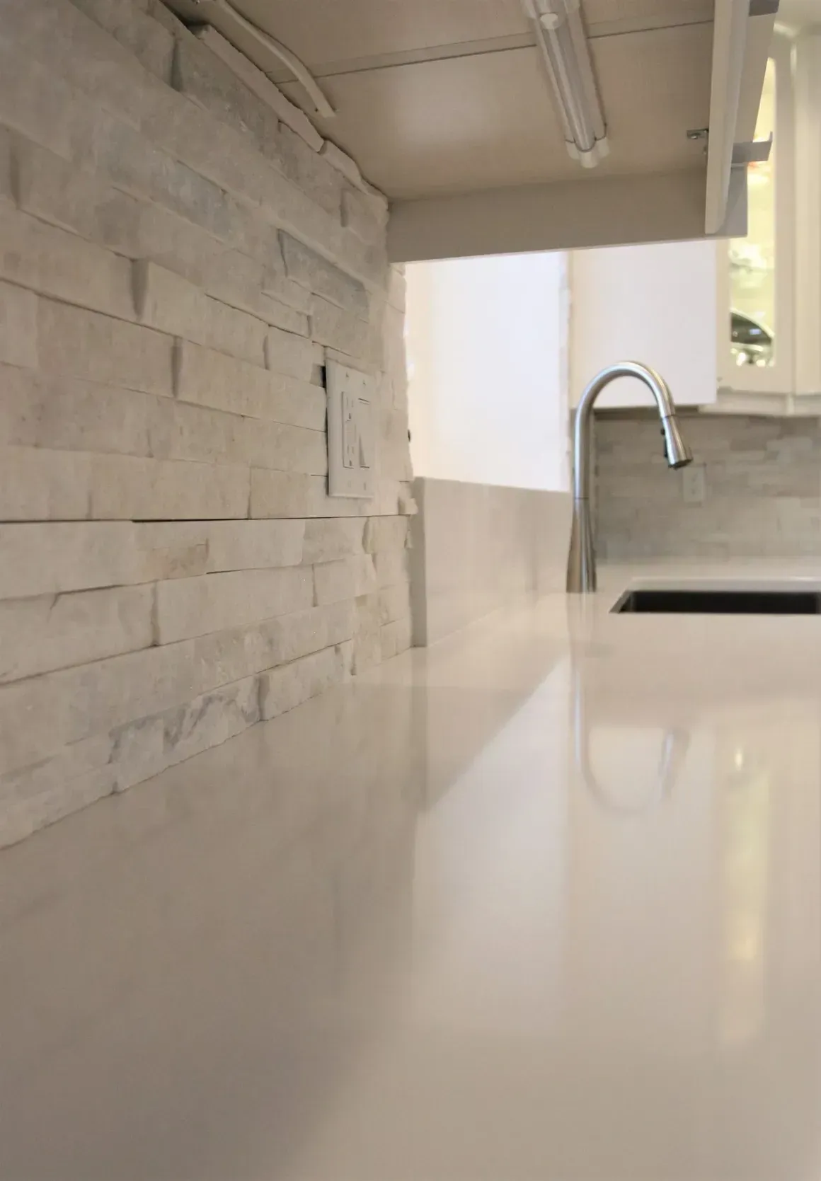 A kitchen counter with a sink and a faucet.