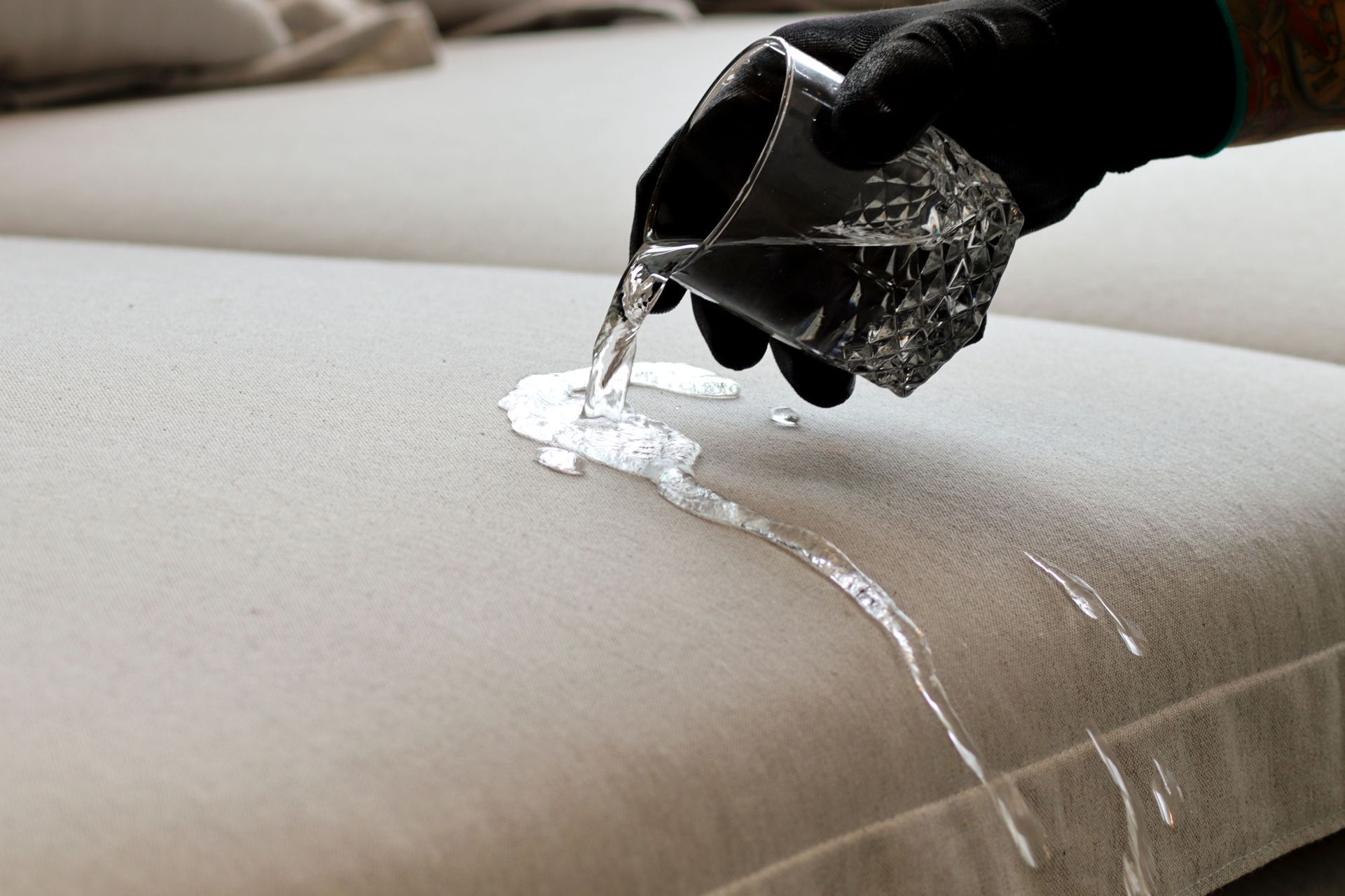 A person is pouring water on a couch.