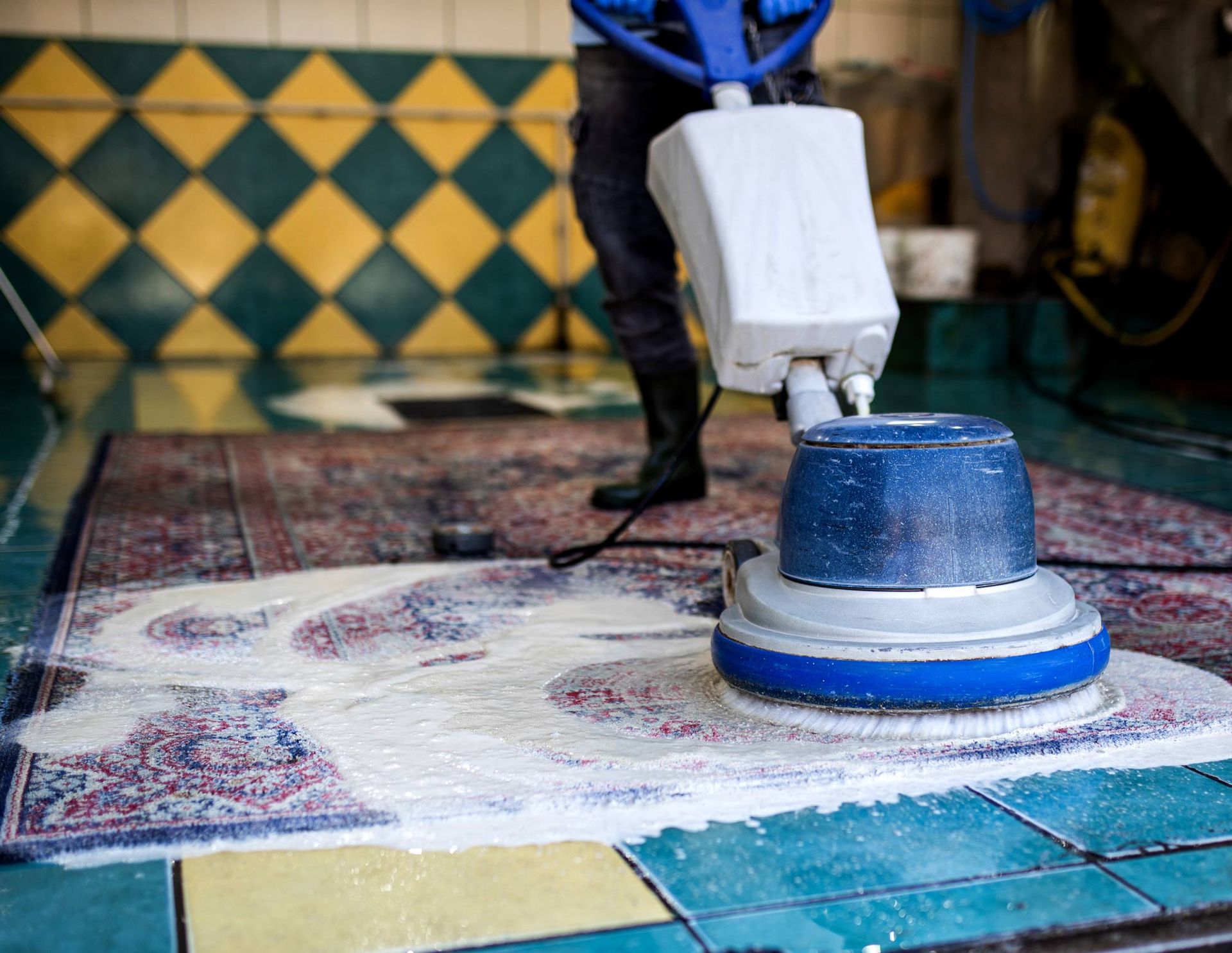 A person is cleaning a rug with a machine.