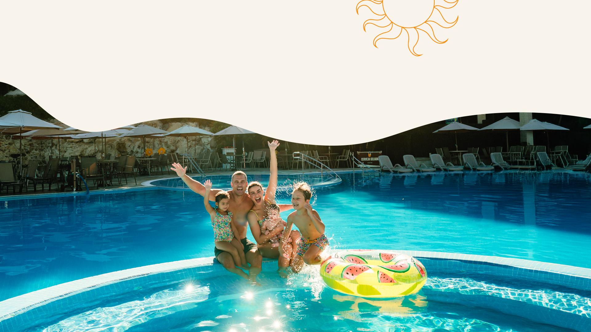 Três pessoas posando em uma piscina azul vibrante de um resort, com uma boia inflável flutuando e uma paisagem montanhosa ao fundo.