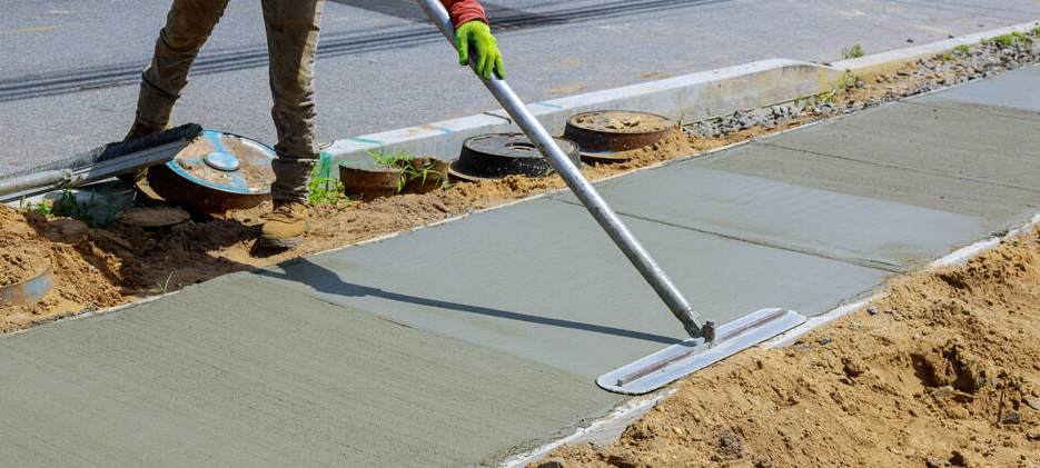 Man With Tool On Concrete Path — Tiga's Concreting Services In Branyan, QLD