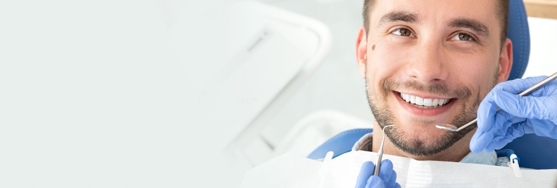 Smiling young man at the dentist, showing healthy teeth and good dental care.