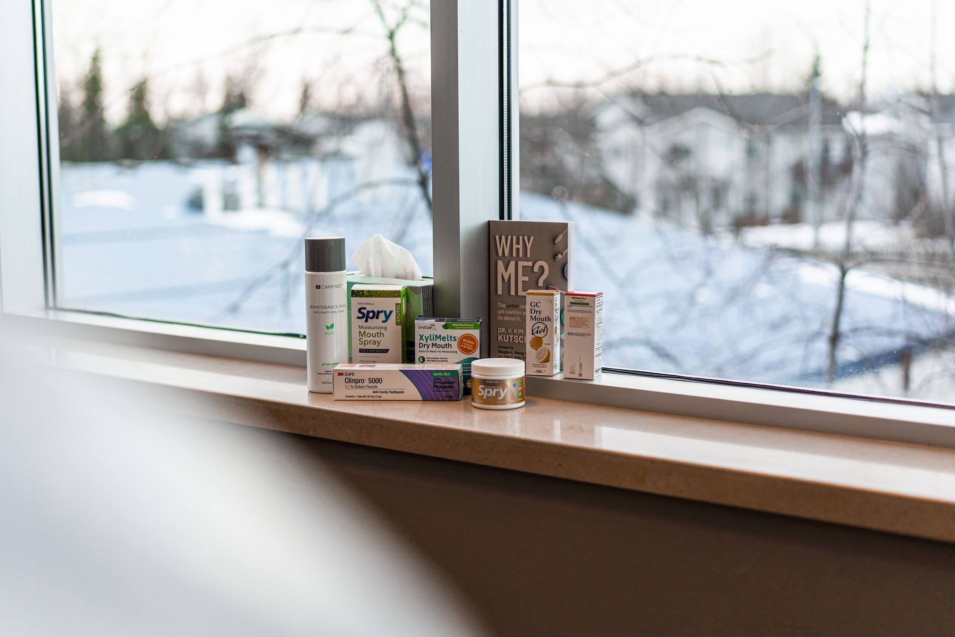 Various product containers arranged on a windowsill, with a snowy outdoor view in the background.