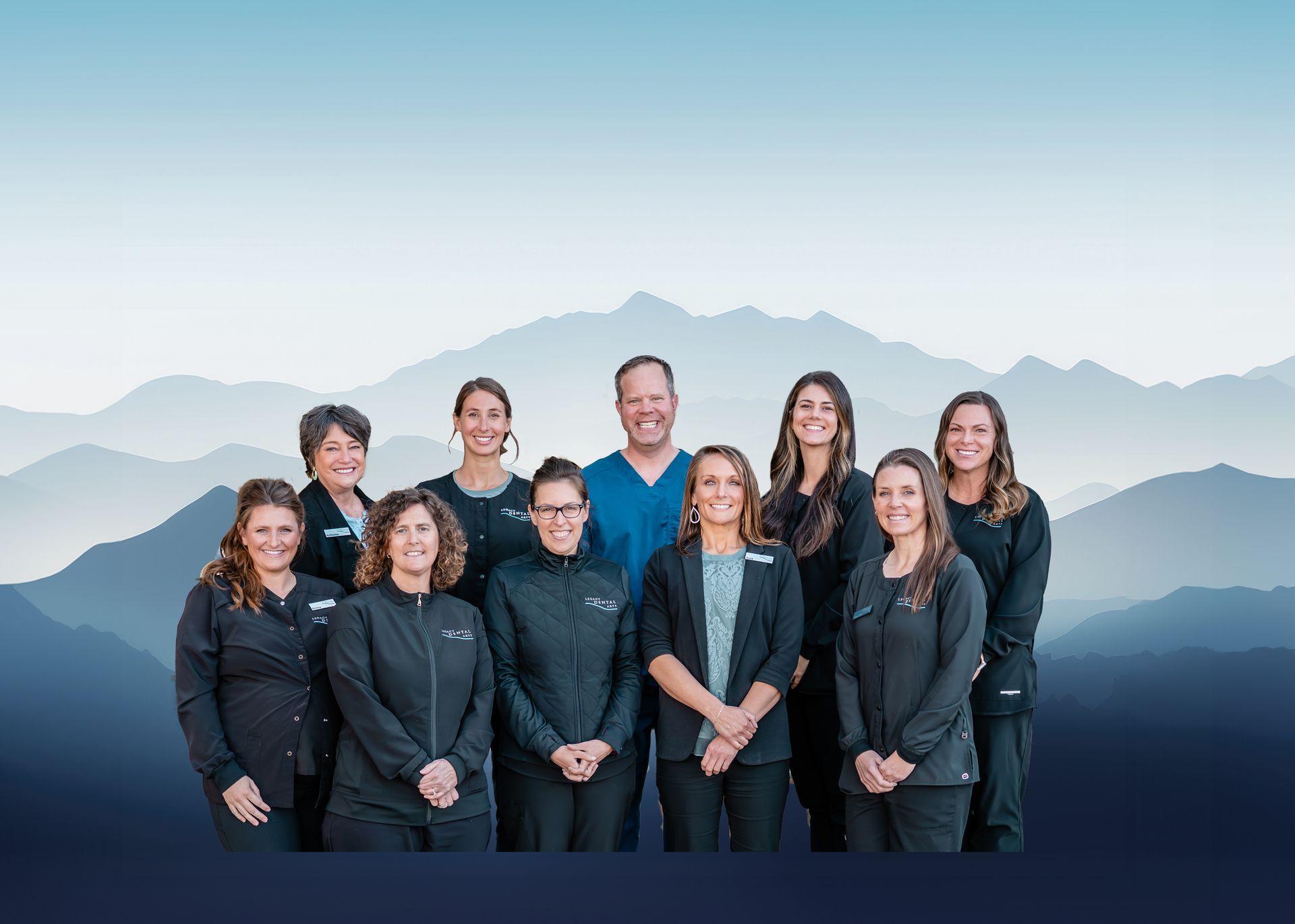 Dental team posing in front of a mountain backdrop.