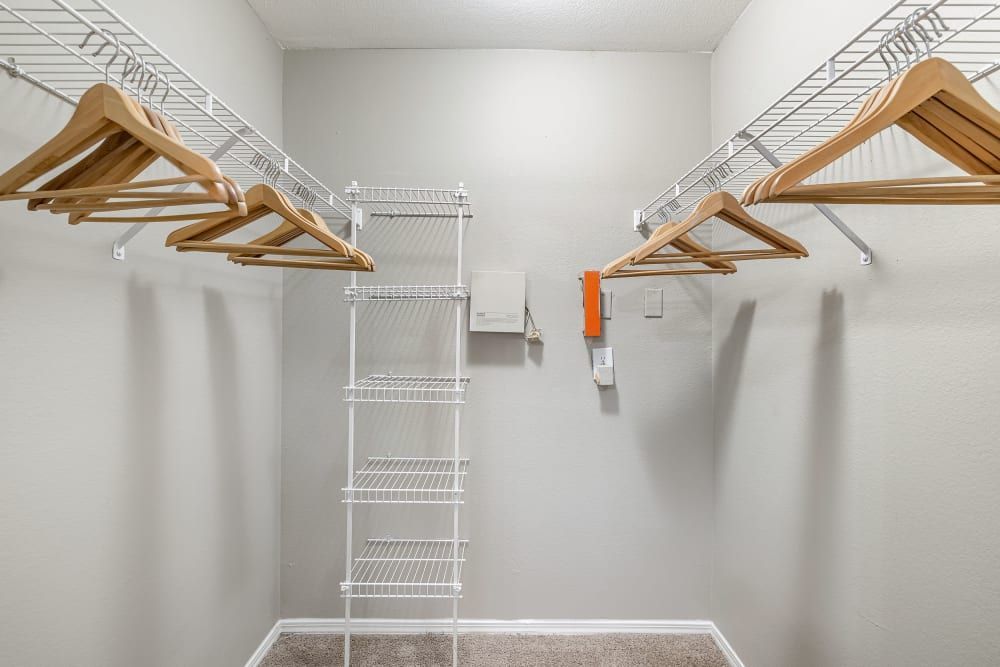 an empty walk-in closet with wooden hangers and a ladder at Marquis on Gaston in Dallas, TX.