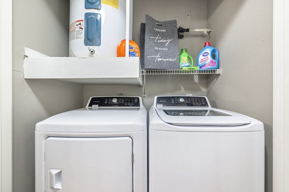 a laundry room with a washer and dryer and a water heater at Marquis on Gaston in Dallas, TX.