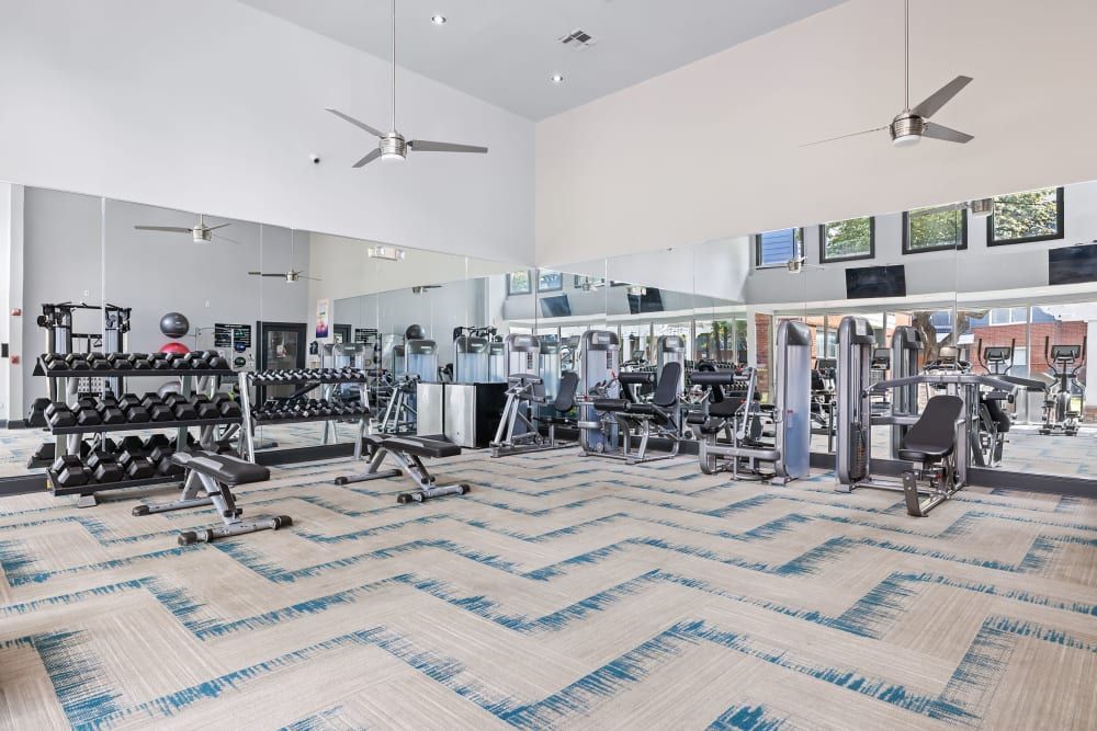 a large gym with a lot of dumbbells and exercise equipment at Marquis on Gaston in Dallas, TX.