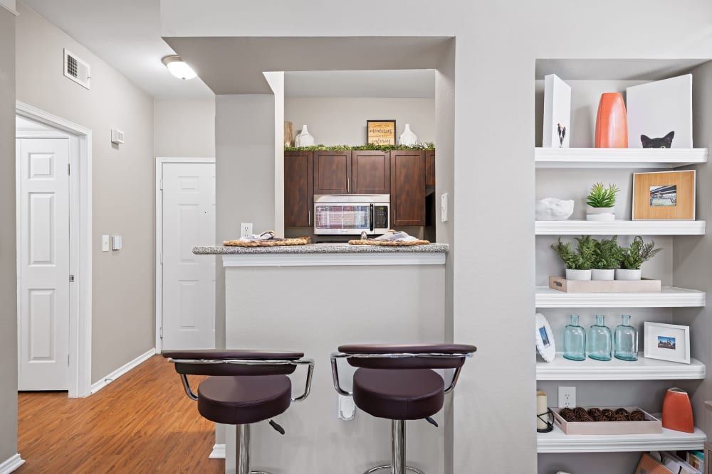 a kitchen with two bar stools and a microwave at Marquis on Gaston in Dallas, TX.