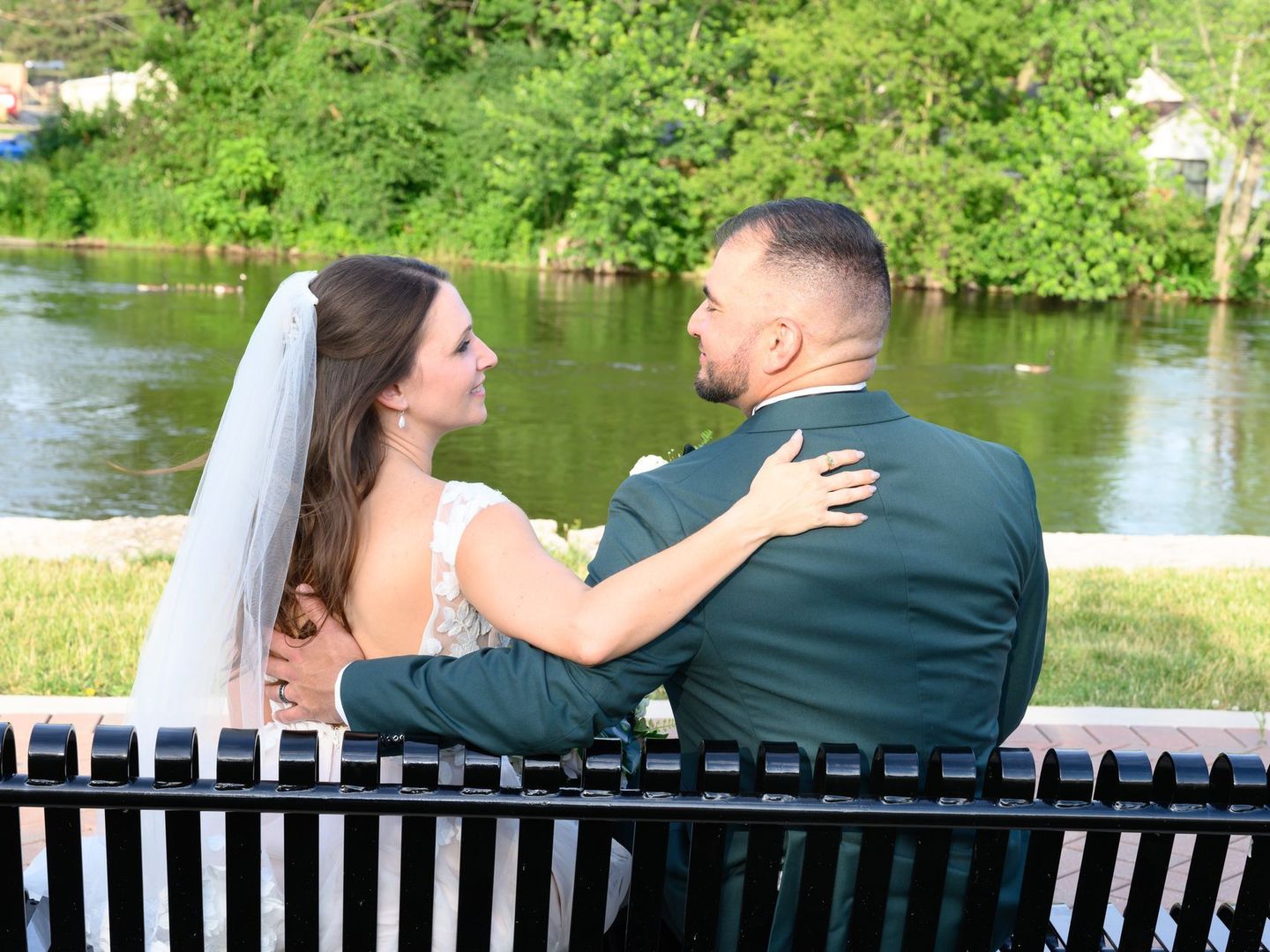newlyweds sitting and enjoying a river in front of them