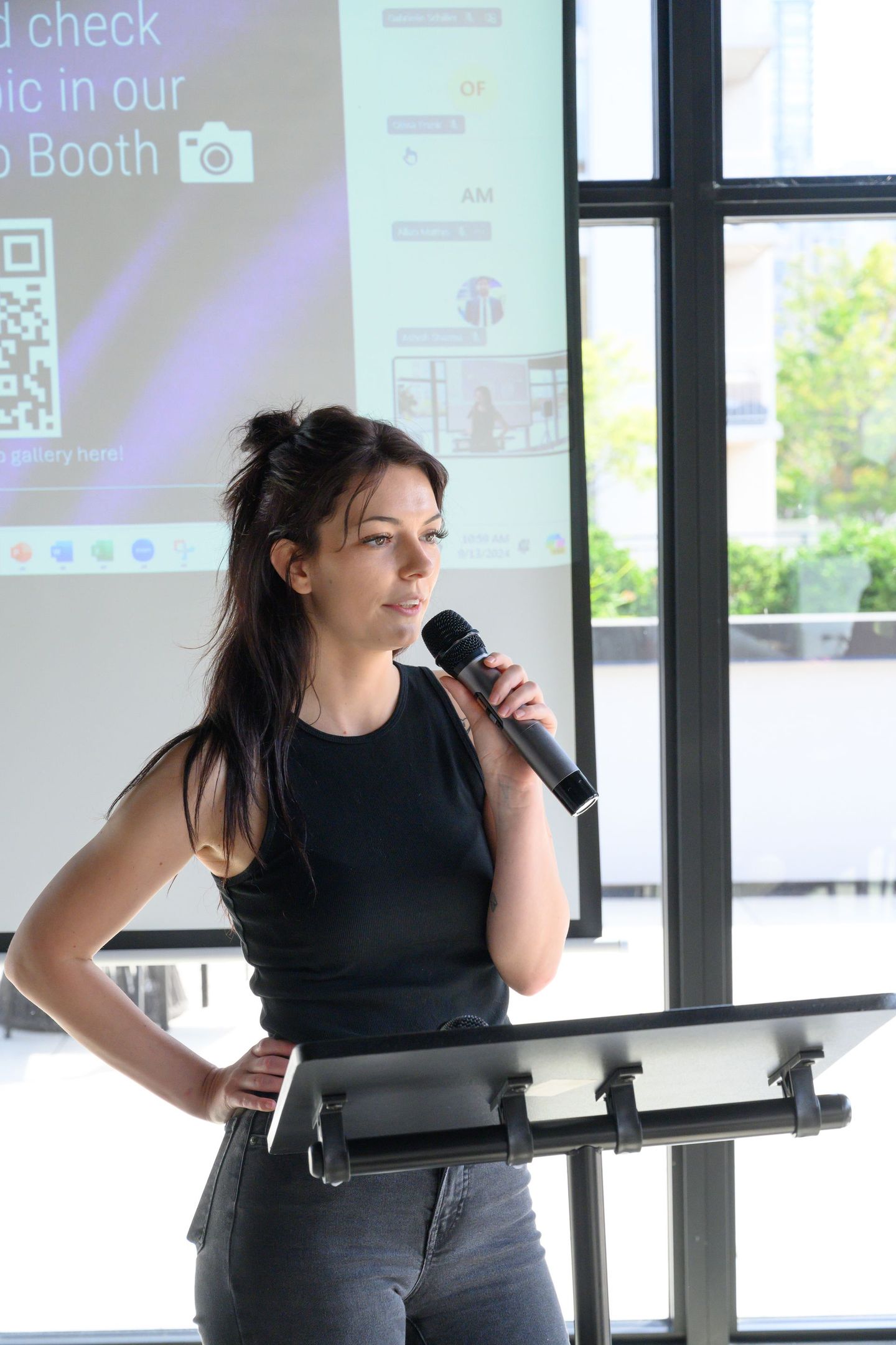 A woman with a mic hosting a conference meeting