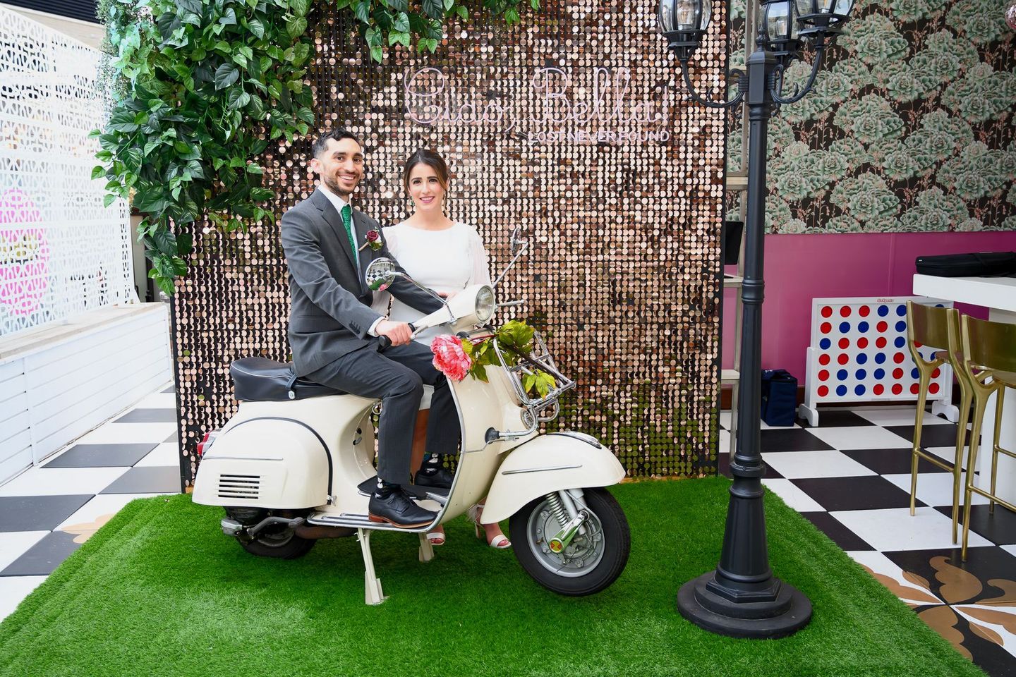 Newlyweds posing in front of a scooter