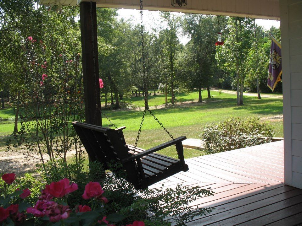 A porch swing with a view of a park