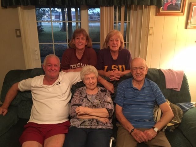 A group of people are posing for a picture on a couch.