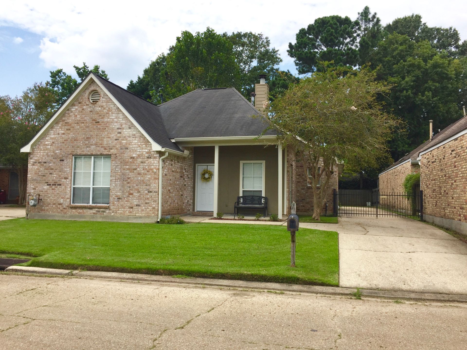 A small brick house with a wreath on the door