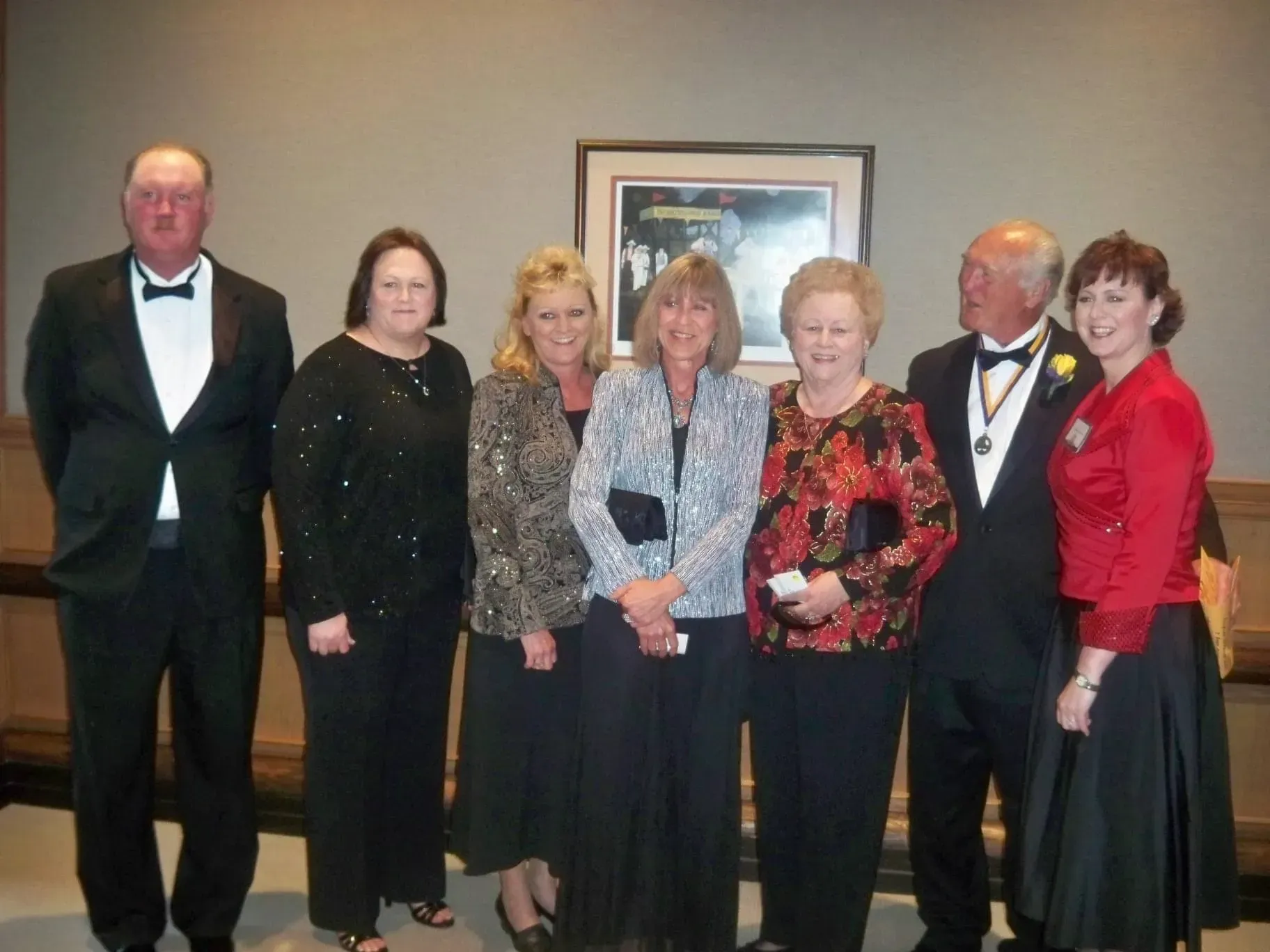 A group of people posing for a picture in front of a picture