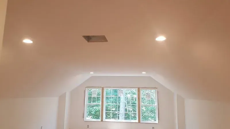 A room with a vaulted ceiling and three windows.