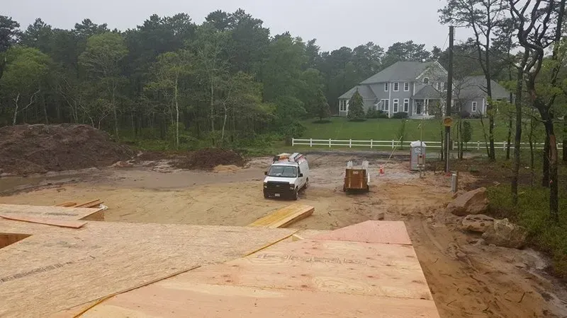A construction site with a house in the background.