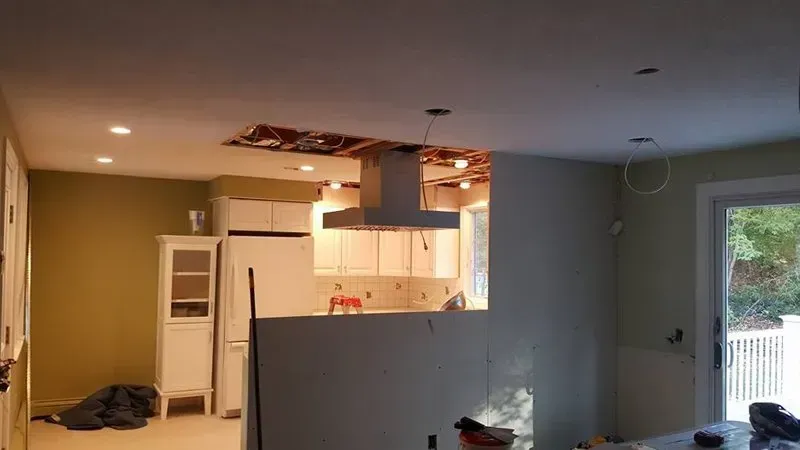 A kitchen under construction with a ceiling fan hanging from the ceiling.