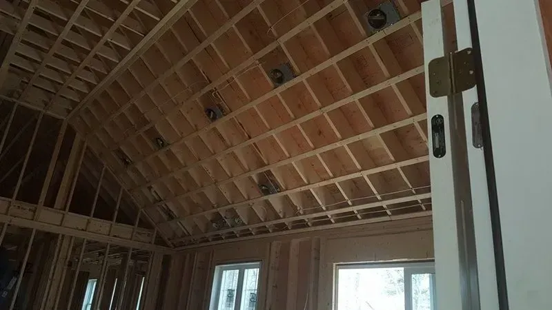 A room in a house under construction with a vaulted ceiling.