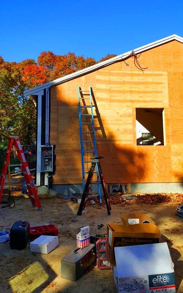 A ladder is sitting in front of a house under construction.