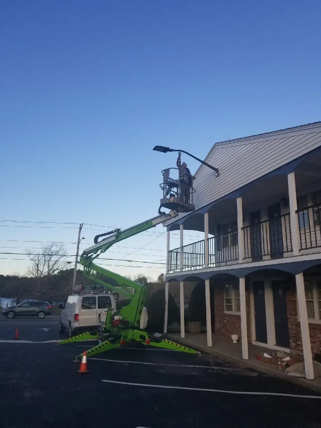 A green crane is working on the roof of a building.